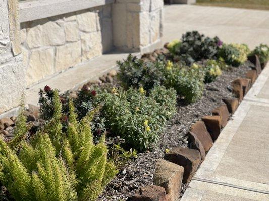 Landscape garden bed maintenance: pruning shrubs, deadheading flowers, cleaning debris.