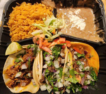 Street tacos (pastor, carne asada, and birria), rice, and beans.