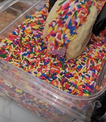 Ice-cream cookie sandwich being rolled in sprinkles...