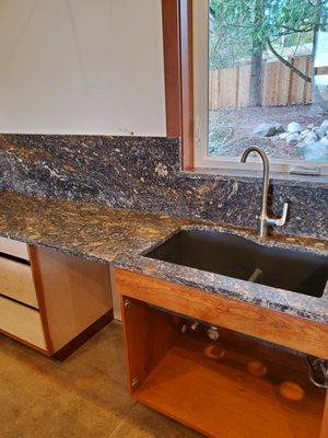 Granite counter with schist.  Black quartz sink.