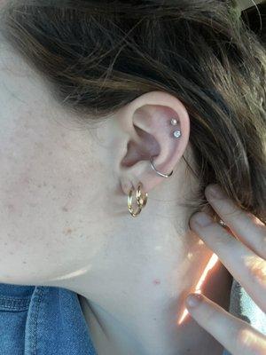 The silver hoop in the middle is the conch piercing done by Aarahm.