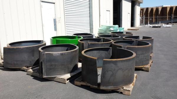 Raw metal tractor fenders ready for a new coat of powder after they are cleaned and blasted at CalHot.