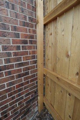 Fence attached to the brick. Brick is being used as a post. This should never be done as it can crack a brick or damage mortar.