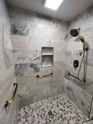 Our latest fully accessible walk-in shower combining modern marble tile and gold fixtures