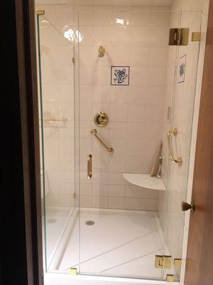 Frameless shower door using brass hardware.