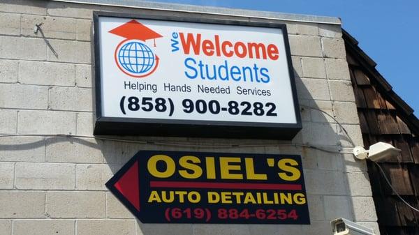 Business sign directing to Osiel's at back of building.