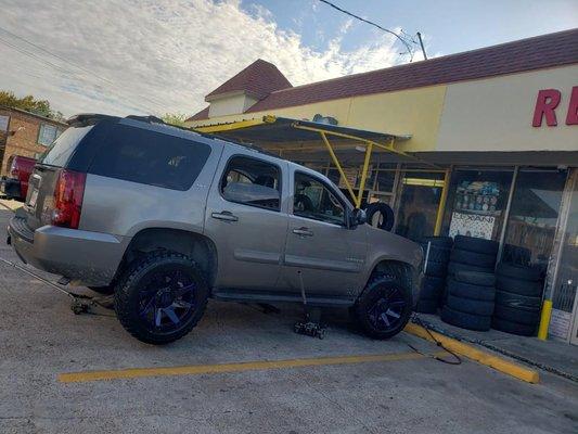 2010 chevy Tahoe with 20 inch black and blue outline wheels with M/T tires