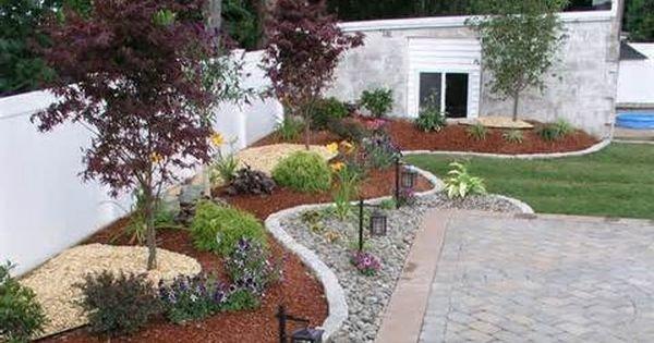 A big side of the yard landscape design. many different materials and plants are use to accomplish this design.