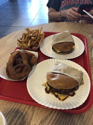 Onion rings, seasoned fries, a Chili cheese burger plain, and a cheese burger with just pickles