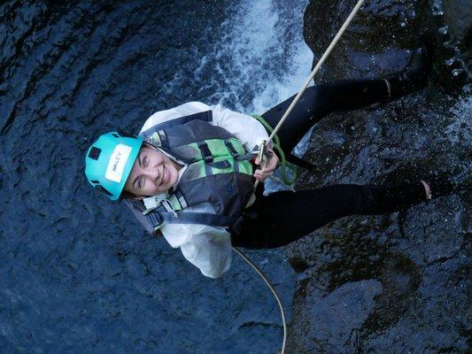 Hailey rappelling next to waterfall