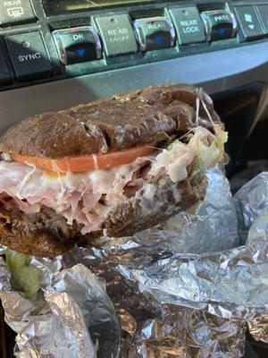 An ooey gooey tasty Ham and cheese on pumpernickel, loaded with a pickle and pepper on the side