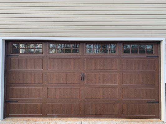 Carriage house bead board panel with decorative hardware in a  walnut wood grain finish.