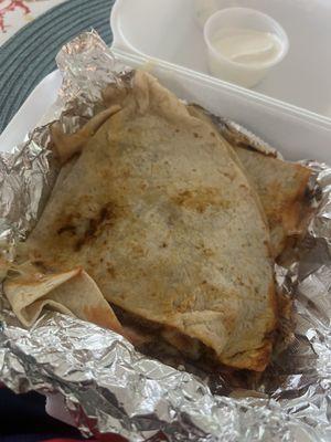 Barbacoa quesadilla with a side of sour cream