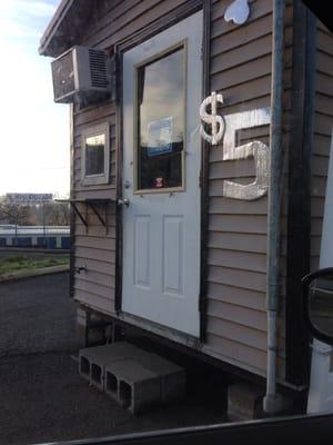 It is in an old drive thru coffee shop! Front door where you bring the dogs in. A lady sits in there and waits for business.