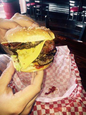 Doppel-Bacon-Cheeseburger mit Salat und BBQ Sauce