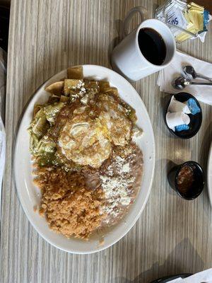 Eggs over medium on top of Chilaquiles in green sauce, refried beans, Spanish rice, queso fresco and black coffee!