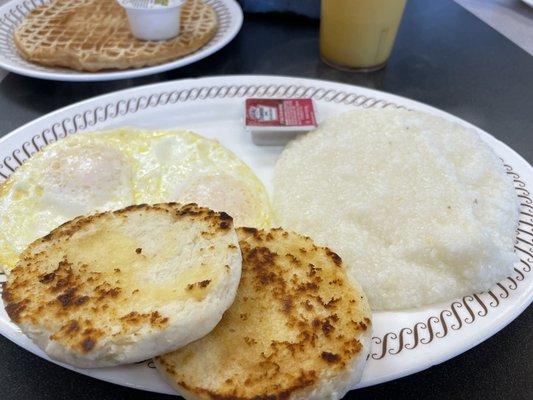 Over easy eggs, biscuit, and grits