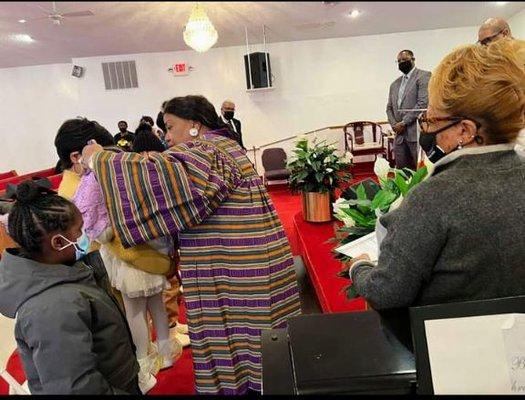 Pastor Carol E. Dixon prays to God in the Name of Jesus and she lays hands on them in  Kainos International Church Detroit, Michigan!!