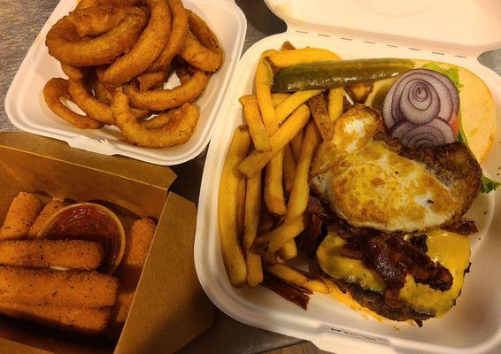 Bacon egg and cheese burger, onion rings, mozzarella sticks