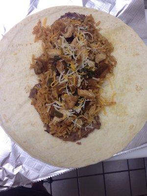 Large chicken fajita taco with refried beans, shredded cheese, homemade rice and homemade chicken with peppers and onion