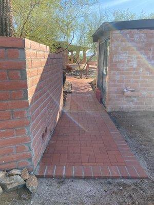 Wall on left side and entry to back yard beside greenhouse.