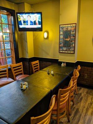 Inside. Group dining room near front of house, with TV. There are several TVs inside. There's also a bar.