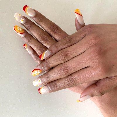 Orange and red nails with floral detail