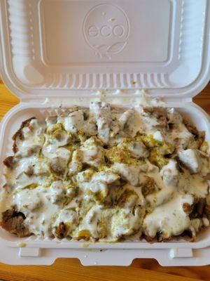 Lamb over rice with white sauce and green sauce