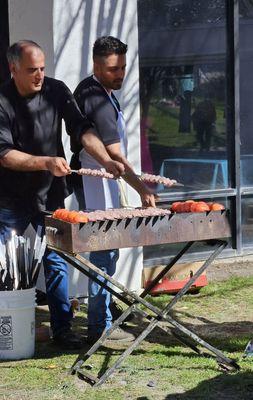 Charcoal grill with fresh tomatoes and kabobs