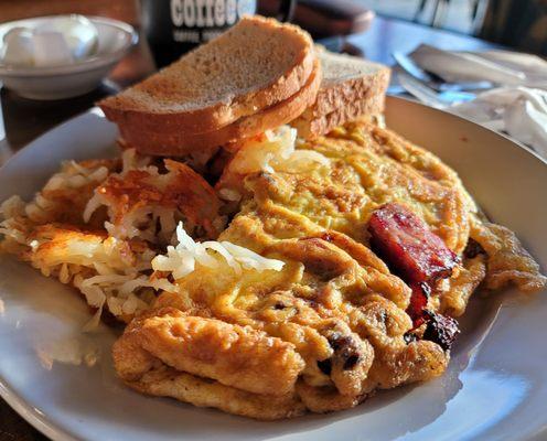 Meat lovers omelet with potatoes and toast