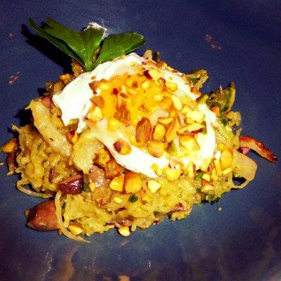 Split portion of creamy spaghetti squash with local mushrooms, asparagus pesto, and a poached farm egg.