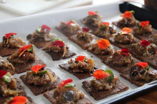 Eggplant tapenade on gluten-free green banana crackers.