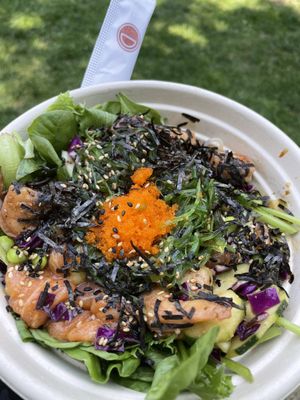 Custom salad with japchae noodles, greens, salmon, tobiko, salmon, shrimp, edamame, seaweed salad, and roasted seaweed