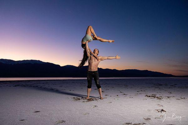 Sunset standing acro duo. Dolphin pose.