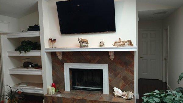 I built the shelving and drywalled the brick wall, tiled the fire place, hung the TV ran all the wires inside the wall and built the mantle