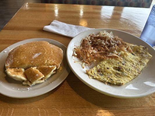 12/02/2023 Hotcakes with a spinach, bacon Swiss omelette and hash browns.