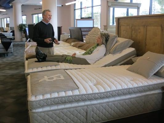 Fred Kunke, owner of The Sleep Shoppe, trains Marie on a new adjustable bed from Aireloom