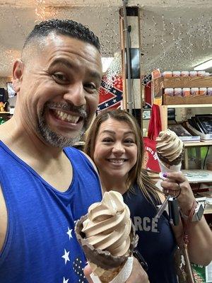 Two happy adults loving the peanut butter and chocolate ice cream cones!!