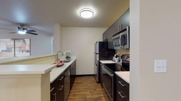 Kitchen featuring hardwood-style vinyl floors and stainless steel appliances.