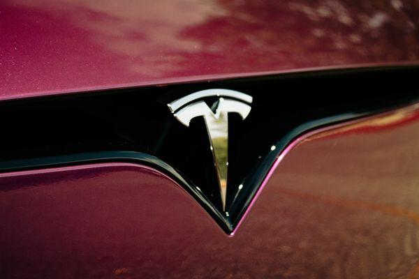 Tesla model S vinyl wrap application in Passionate purple by teckwrap. Tesla Logo