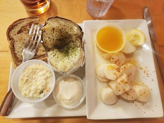 Sautees scallops with drawn butter, baked potato, coleslaw, and rye bread