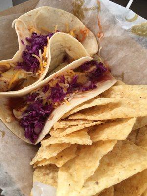 Mahi-mahi tacos with chips. Perfectly grilled fish chunks with a light cream sauce and chopped red cabbage.