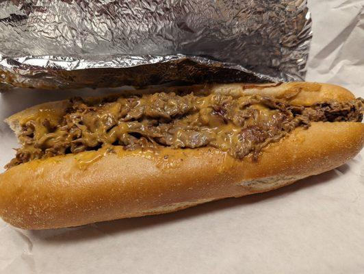 The delicious cheese steak sub with onions, Whiz and a bite missing.  Yum!