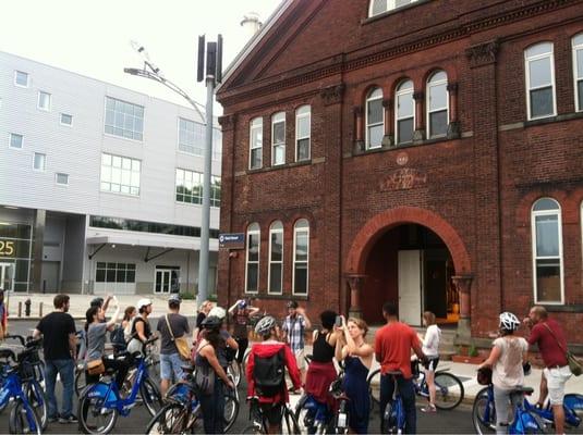 The sustainable architecture and industry tour stops outside the historic building of Kings County Distillery.