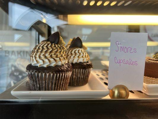 S'mores cupcakes. Love that they got the toasting effect on the frosting. Beautiful piping highlights the texture.