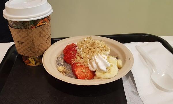 'A healthy breakfast. Organic coffee.  A Chia seed pudding bowl with fresh strawberries, bananas, walnuts & coconut whipped cream.