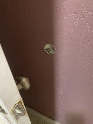 Hole in wall behind door