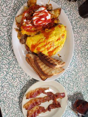 Home fries with cheese and onions, a meat lovers omelet, toast and a side of bacon.