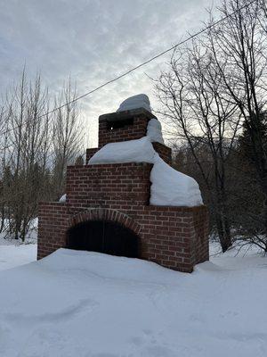 Outdoor fireplace covered in snow