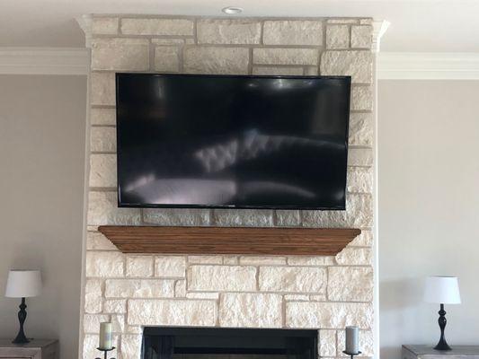 TV mounted over fireplace.